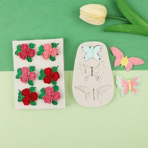 Detailed silicone molds for DIY rose and butterfly candles with colorful finished samples
