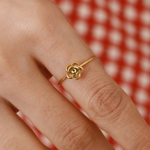 Detail shot of a 18k gold plated stainless steel rose ring worn on a finger