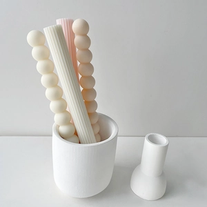 Close-up of ribbed pillar and bubble shaped candles in cream white and pastel pink tones