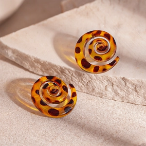 Macro shot of amber resin snail spiral earrings with brown leopard print pattern