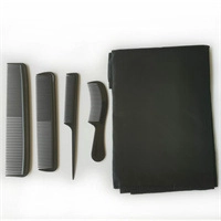 Flat lay of professional hair cutting set with four black combs and folding cape on white