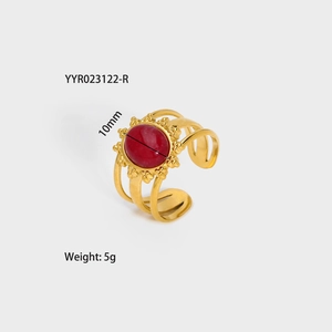 Detail view of gold stainless steel ring with red oval stone and multi-layer band design