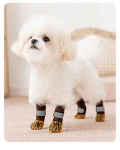 Detail view of anti-slip dog leg warmers with reflective straps on a white puppy