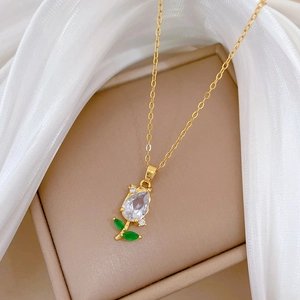 Close-up of tulip pendant featuring pear-cut clear gem and green leaf-shaped stones