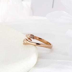 Macro shot of rose gold hugging hands ring detailing the adjustable open band design
