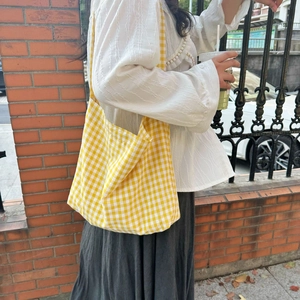 Outdoor shot of a large plaid canvas tote bag showing its texture and capacity
