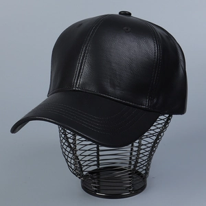 Detail of black PU leather baseball cap showing fine grain texture and 6-panel stitching