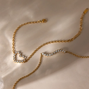 Détail du bracelet en acier inoxydable 18K avec pendentif cœur serti de zircons blancs