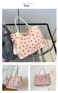 Detailed view of a pink corduroy tote bag with red strawberry patterns and utility pockets