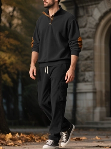 Detail of black corduroy Henley sweatshirt with brown patchwork on elbows and collar