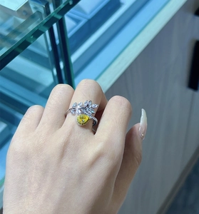 Detail of leaf-shaped ring with yellow teardrop zircon worn on a woman's finger