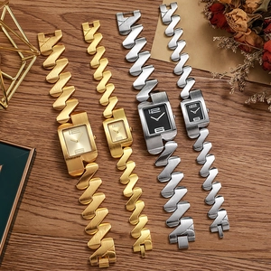 Vintage square gold and silver quartz watches with Z-shaped metal bracelets on wood