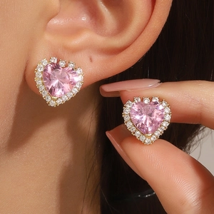 Detalle de pendientes de corazón rosa con circonitas cúbicas y marco en color oro