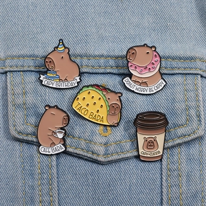 Cartoon Capybara enamel pin set with food themes pinned on blue denim fabric
