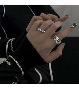 Detail shot of silver irregular geometric rings and tennis bracelet set on model