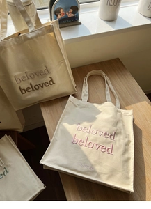 Close-up of triple-layered colorful beloved embroidery on high-quality cream canvas tote