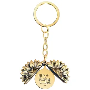 Close-up of golden sunflower keychain with hidden engraved message KEEP GOING inside