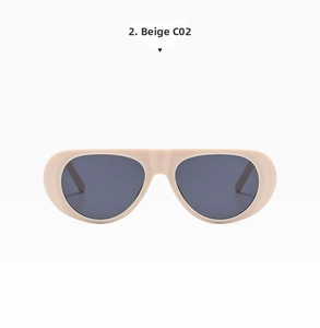 Detail shot of beige wide-frame sunglasses with dark gray lenses and integrated nose pads