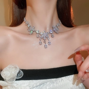Detail of floral zircon necklace with water drop pendant on neck model in warm light