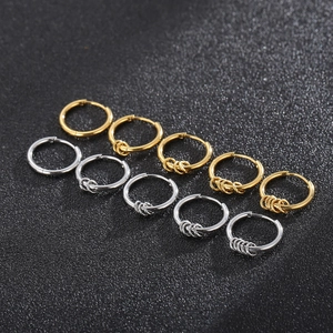 Minimalist stainless steel hoop earrings in gold and silver finish on a textured background