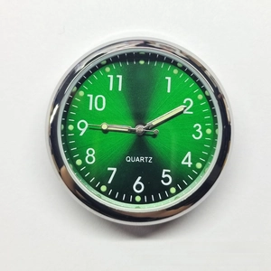Macro shot of 40mm luminous quartz car clock with green sunray dial and silver bezel