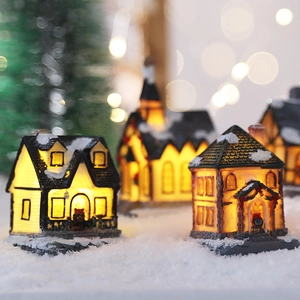 Illuminated Christmas miniature house set with snow landscape and festive holiday decorations