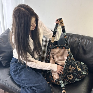 Detail of plush tote bag interior featuring check lining and zipper pocket space