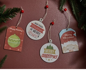 Dettaglio di ornamenti natalizi in legno con motivi di Babbo Natale e perline rosse