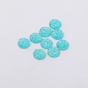 Close-up of 12mm turquoise druzy resin flatback cabochons with sparkling glitter texture