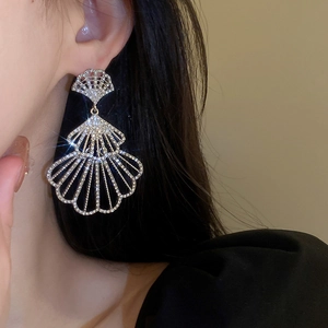 Macro shot of silver tiered fan-shaped earrings encrusted with sparkling zircons