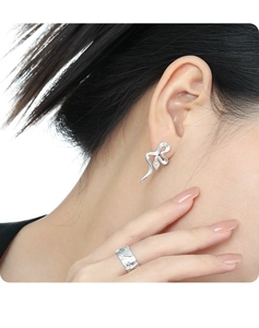 Detail view of S925 silver snake texture earrings and ring set on model skin