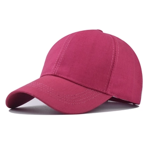Detail of rose red cotton baseball cap showing textured twill fabric and curved brim