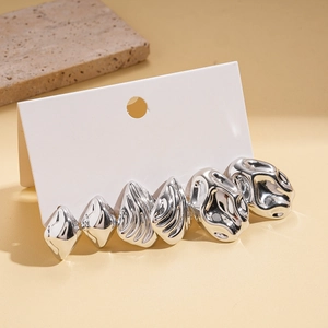 Macro shot of a 3-pair silver earring set featuring liquid metal aesthetic and textured shapes