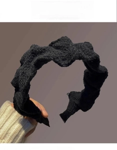 Close-up of black textured teddy fleece headband featuring elegant pleated fabric details