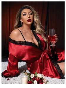 Detail of red satin robe with black lace trim and silk finish on the V-neck design