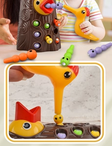 Close-up of magnetic woodpecker toy catching colorful worms from a tree stump base