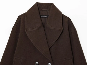 Détail du manteau en laine marron avec large revers, boutons croisés et texture épaisse