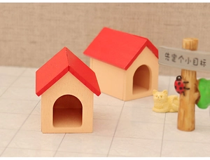 Miniature Christmas dollhouse scene with red wooden houses, cat figurine and signpost