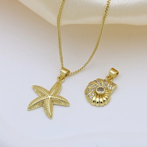 Gold ocean necklace featuring starfish and shell pendants with crystals on silk fabric