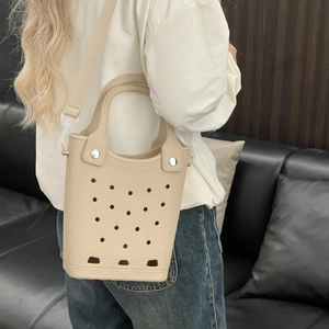 Beige EVA beach tote bag shown on shoulder with woven strap in a lifestyle setting