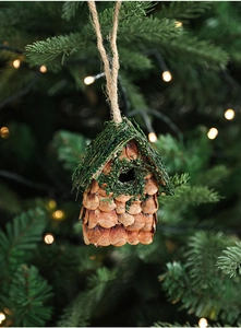 Détail d'un ornement nichoir avec écailles de pomme de pin et mousse sur un sapin