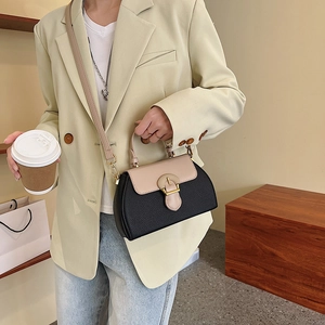 Detail of color-block tote bag in lychee leather featuring a beige flap and metal buckle