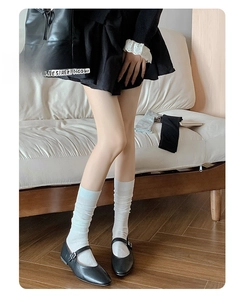Close-up of white ribbed calf socks styled with black Mary Jane shoes for balletcore look