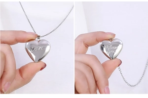 Detailed view of silver heart locket showing Love engraving and internal photo frame