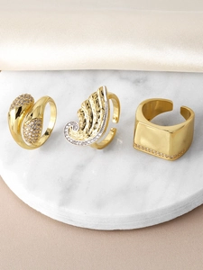 Detailed view of three gold adjustable rings featuring zircon inlay on a marble base