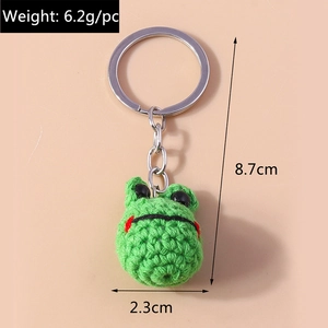 Detail of handmade crochet green frog keychain showing precise dimensions and 6.2g weight