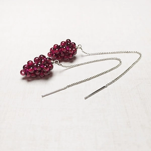 Close-up of handmade burgundy garnet grape cluster earrings on silver long chains