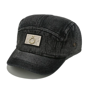 Detail of washed denim 5-panel camper hat with fabric patch and gold ring metal logo