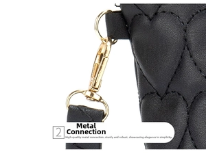 Detail of golden metal clip on black heart-quilted crossbody bag with high texture