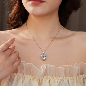Détail d'un collier floral avec cristal rose et pétales bleus sur un mannequin